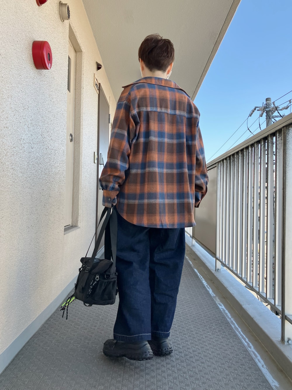 オレンジ系のシャツ/ブラウス、ホワイト系のTシャツ/カットソー、ブラック系のスニーカーを着用したレディースの秋コーディネートの2枚目の写真