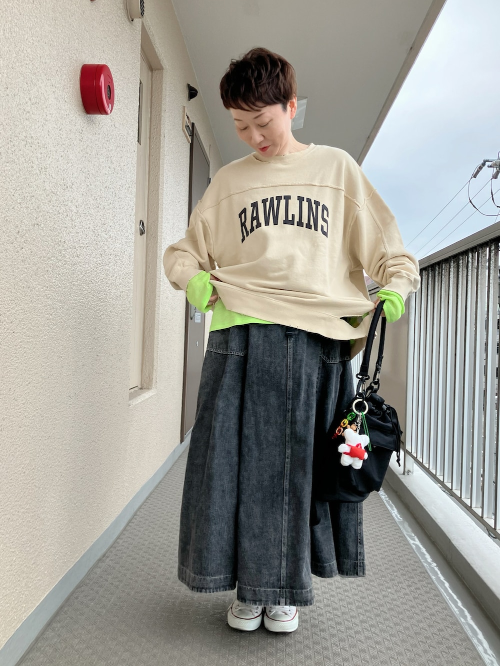 ホワイト系のスウェット、グリーン系のTシャツ/カットソー、ブラック系のショルダーバッグを着用したレディースの春コーディネートの2枚目の写真