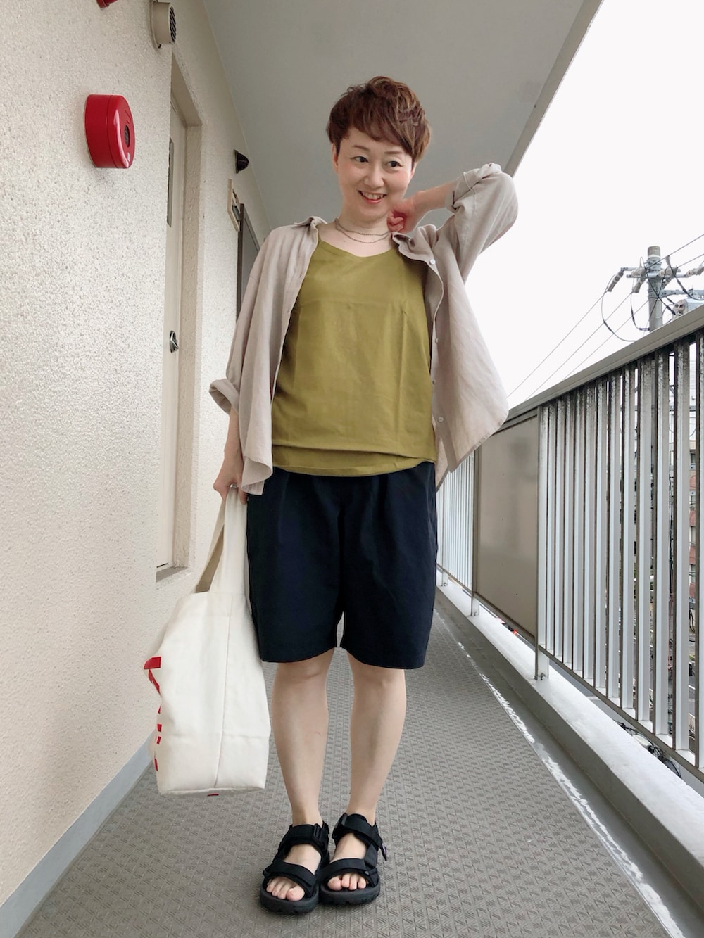 イエロー系のタンクトップ、ブラック系のその他パンツ、ブラック系のサンダルを着用したレディースの夏コーディネートの2枚目の写真