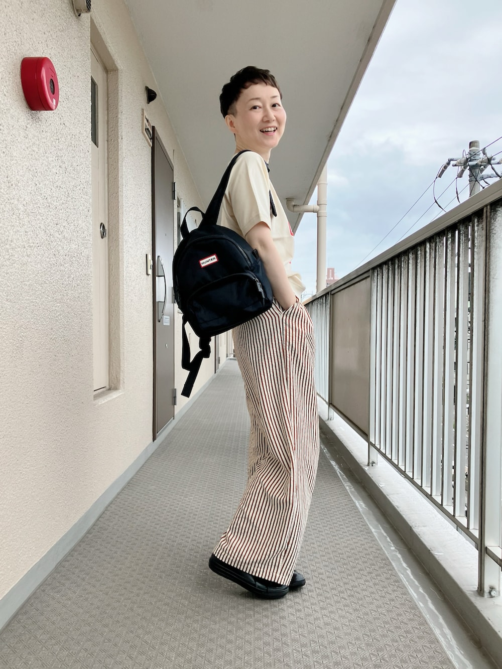 ホワイト系のTシャツ/カットソー、ブラウン系のその他パンツ、ブラック系のバックパック/リュックを着用したレディースの秋コーディネートの3枚目の写真
