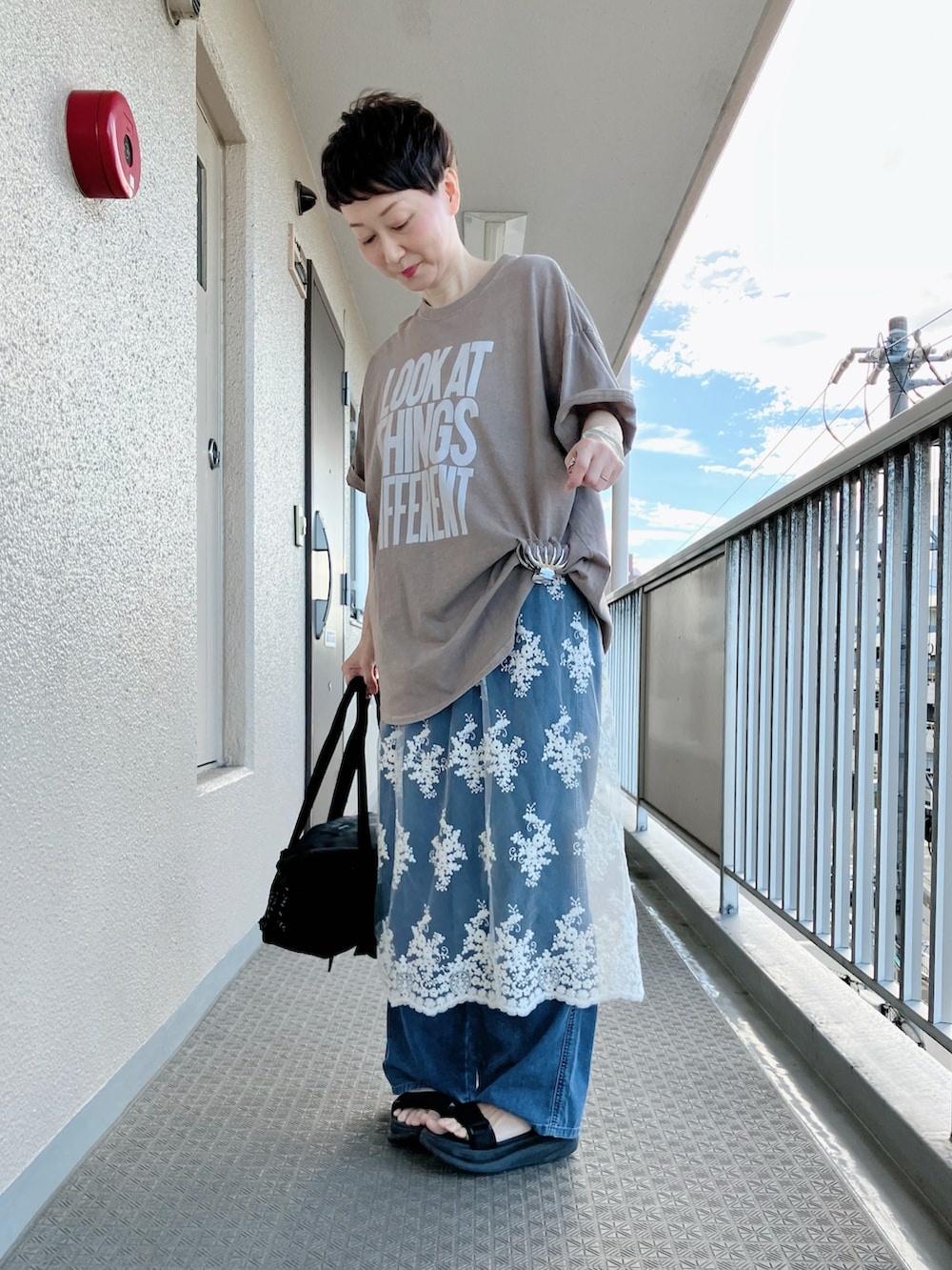 ベージュ系のTシャツ/カットソー、ホワイト系のスカート、ブルー系のデニムパンツを着用したレディースの夏コーディネートの2枚目の写真