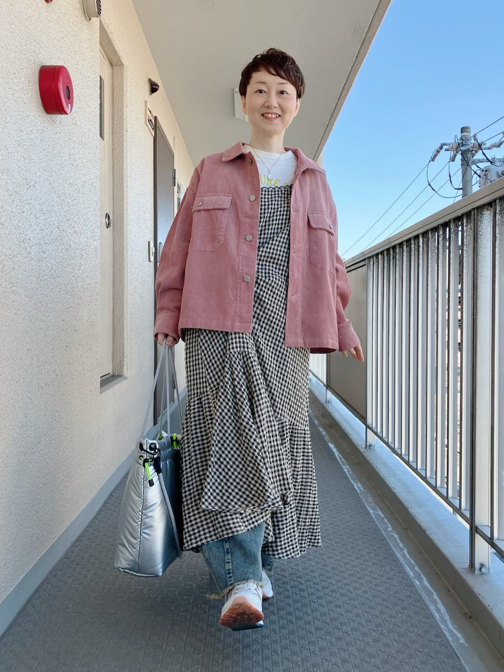 ベージュ系のワンピース、ピンク系のブルゾン、ホワイト系のTシャツ/カットソーを着用したレディースの冬コーディネートの2枚目の写真