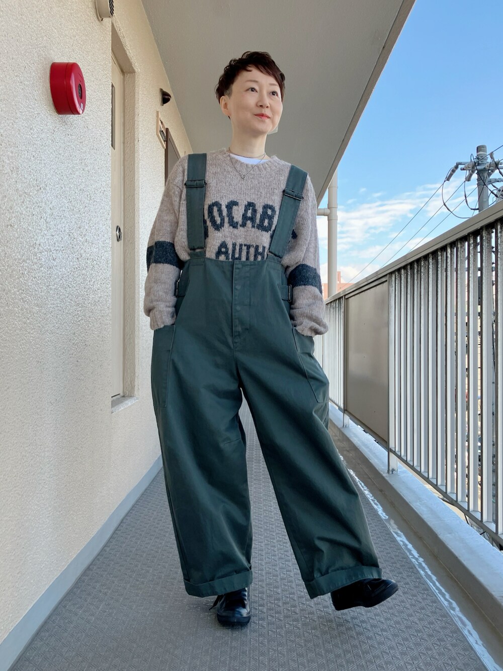 ベージュ系のニット/セーター、ブルー系のブルゾン、グリーン系のサロペット/オーバーオールを着用したレディースの冬コーディネートの3枚目の写真