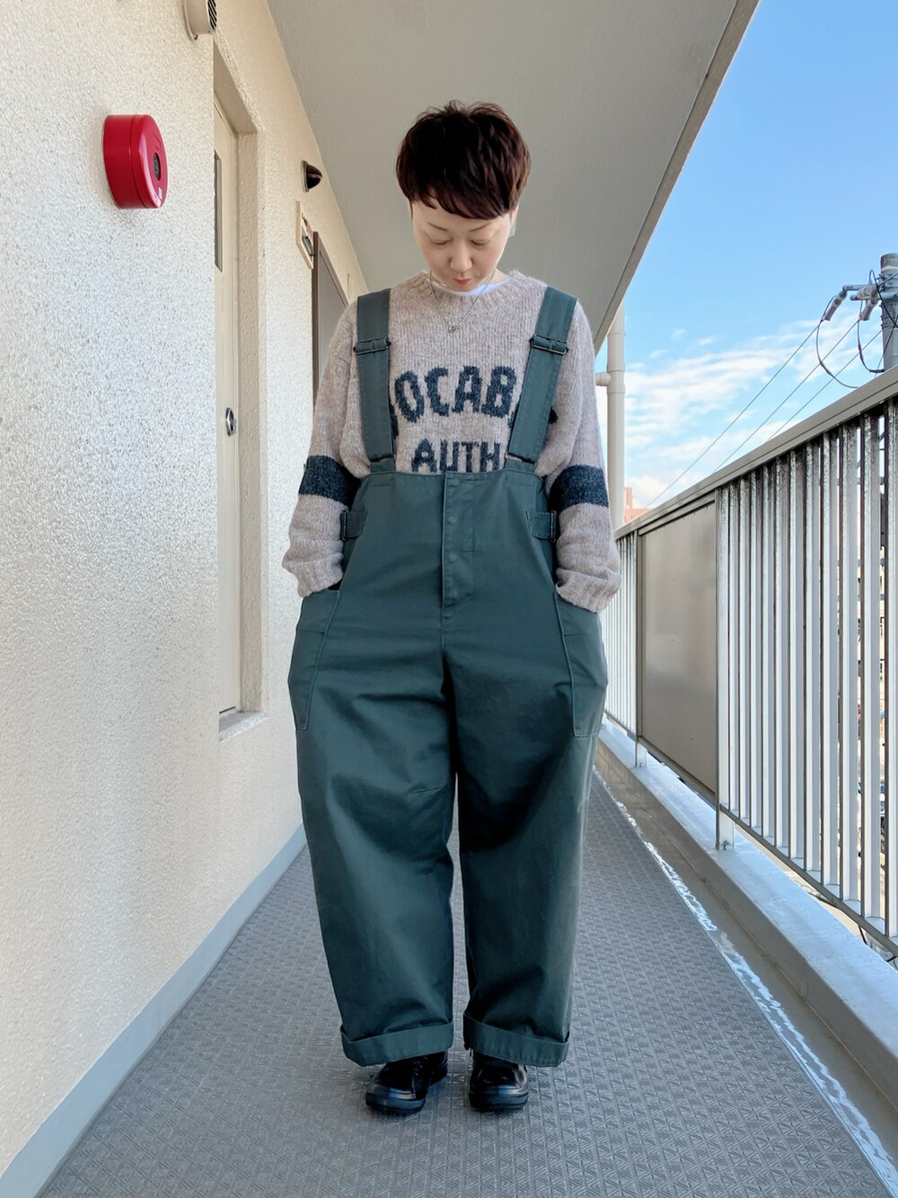 ベージュ系のニット/セーター、ブルー系のブルゾン、グリーン系のサロペット/オーバーオールを着用したレディースの冬コーディネートの2枚目の写真