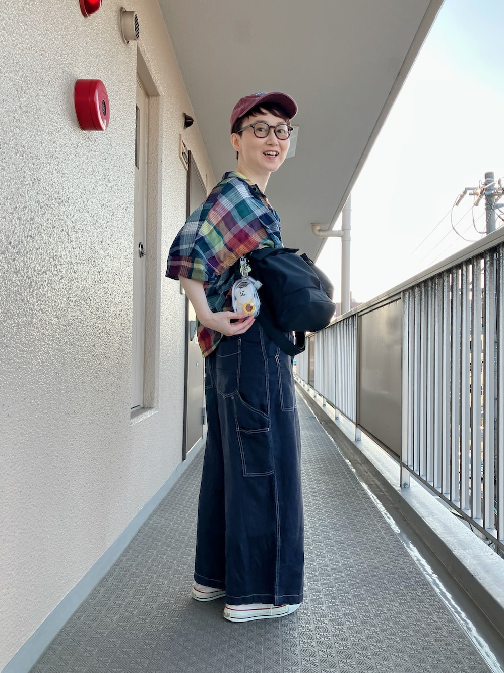 ブルー系のシャツ/ブラウス、ベージュ系のTシャツ/カットソー、ブラック系のサロペット/オーバーオールを着用したレディースの秋コーディネートの3枚目の写真