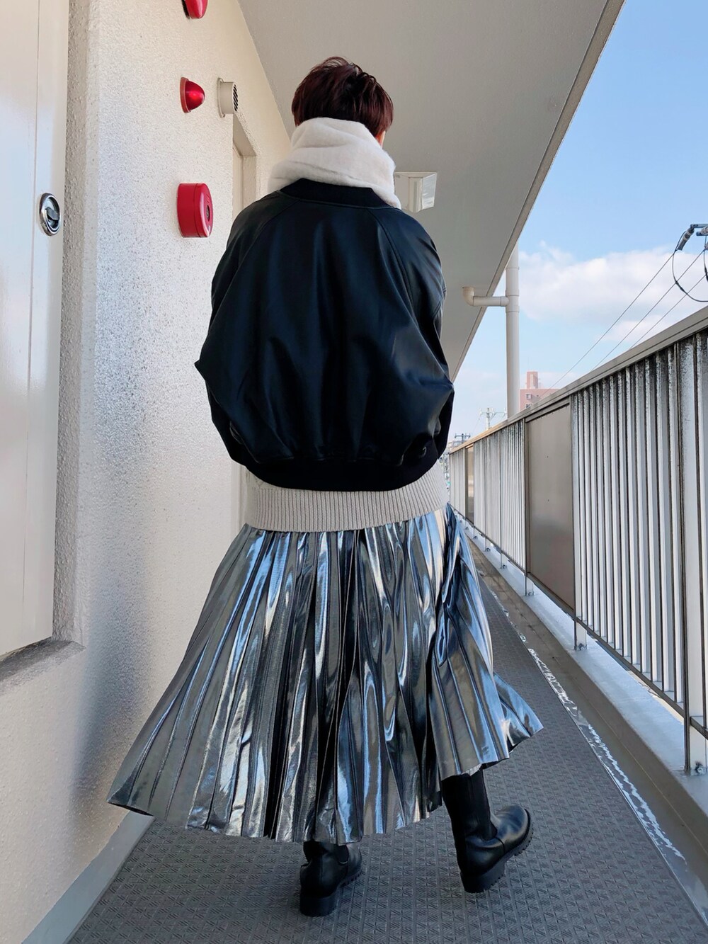 ブラック系のその他アウター、ベージュ系のニット/セーター、シルバー系のスカートを着用したレディースの冬コーディネートの2枚目の写真