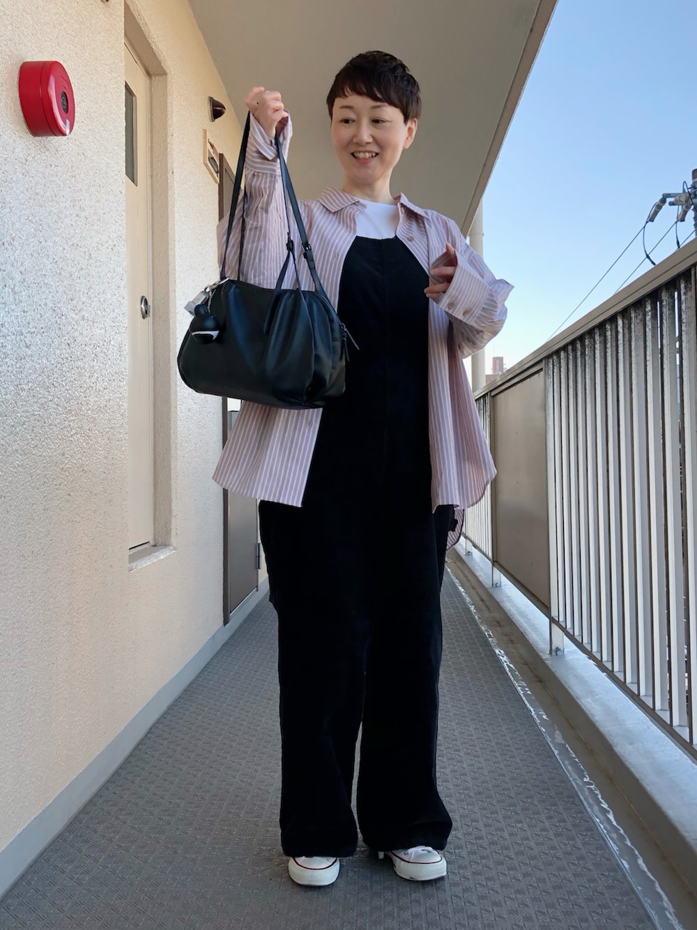 ベージュ系のシャツ/ブラウス、ホワイト系のサロペット/オーバーオール、ホワイト系のスニーカーを着用したレディースの秋コーディネートの2枚目の写真