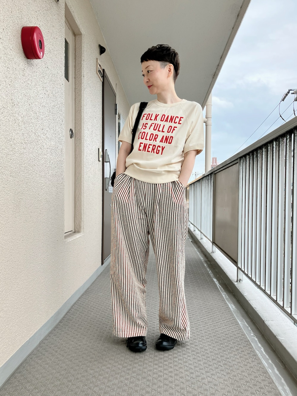 ホワイト系のTシャツ/カットソー、ブラウン系のその他パンツ、ブラック系のバックパック/リュックを着用したレディースの秋コーディネートの2枚目の写真