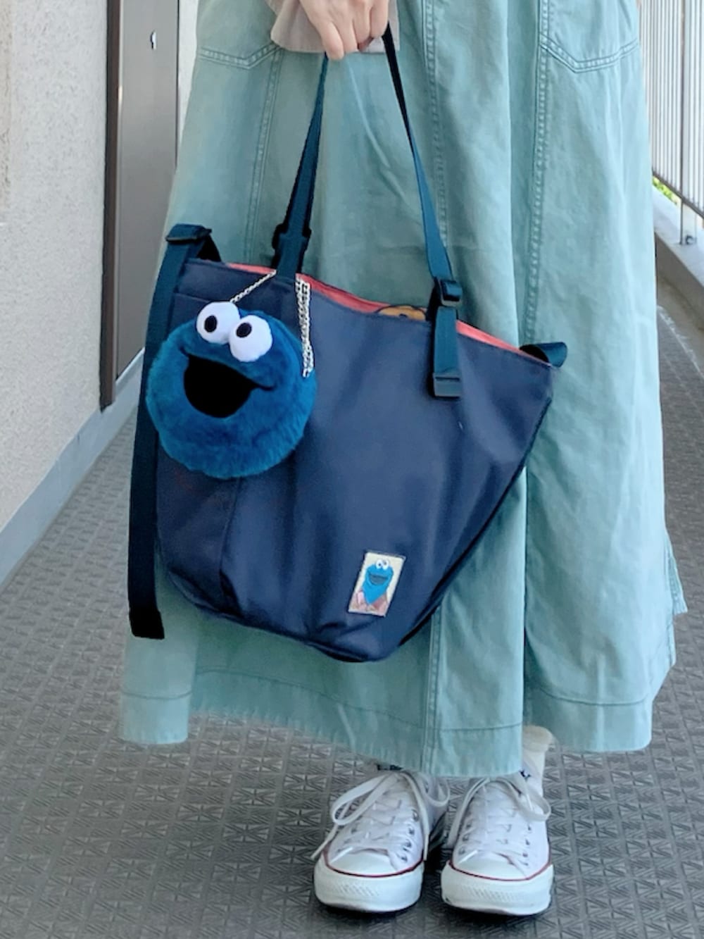 ホワイト系のTシャツ/カットソー、グリーン系のスカート、ブルー系のトートバッグを着用したレディースの春コーディネートの3枚目の写真