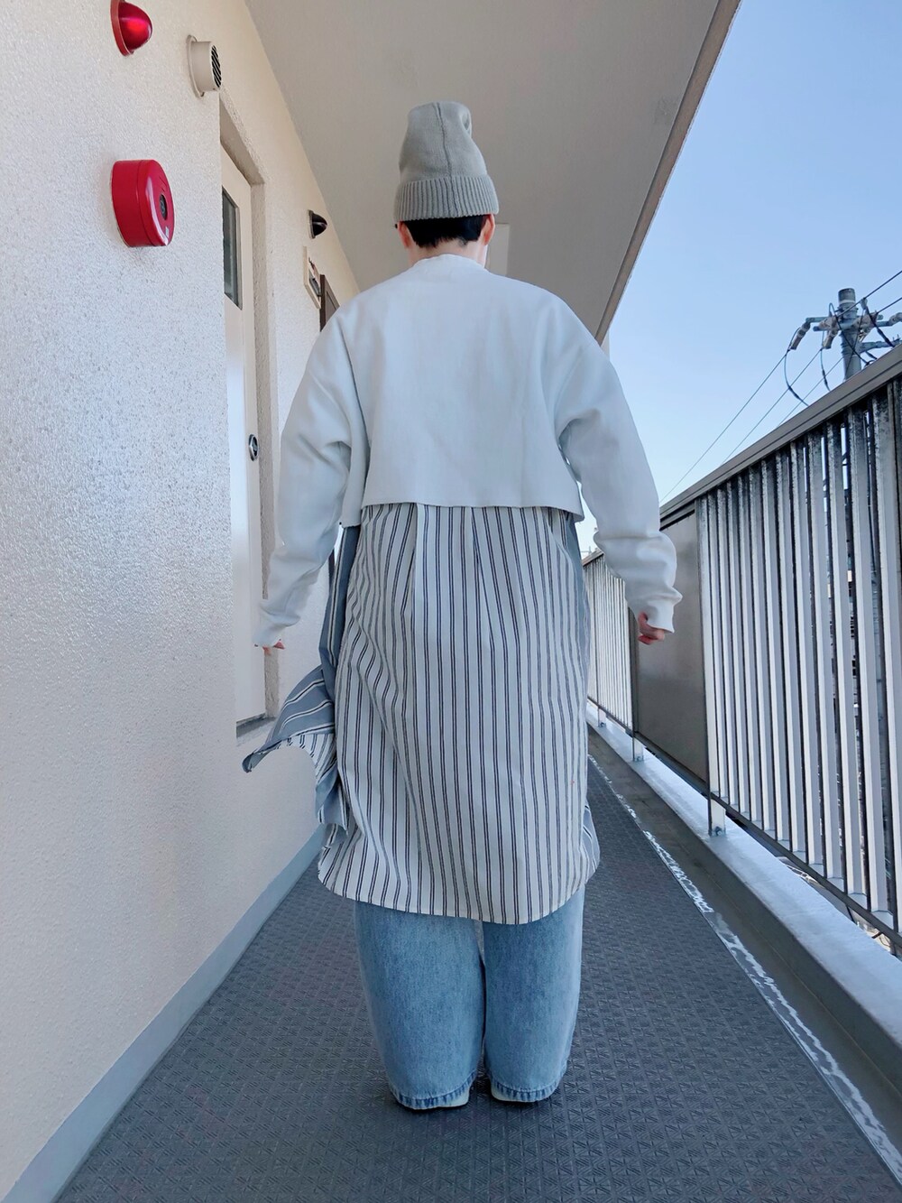 ホワイト系のスウェット、ブルー系のデニムパンツ、ベージュ系のニットキャップ/ビーニーを着用したレディースの春コーディネートの3枚目の写真