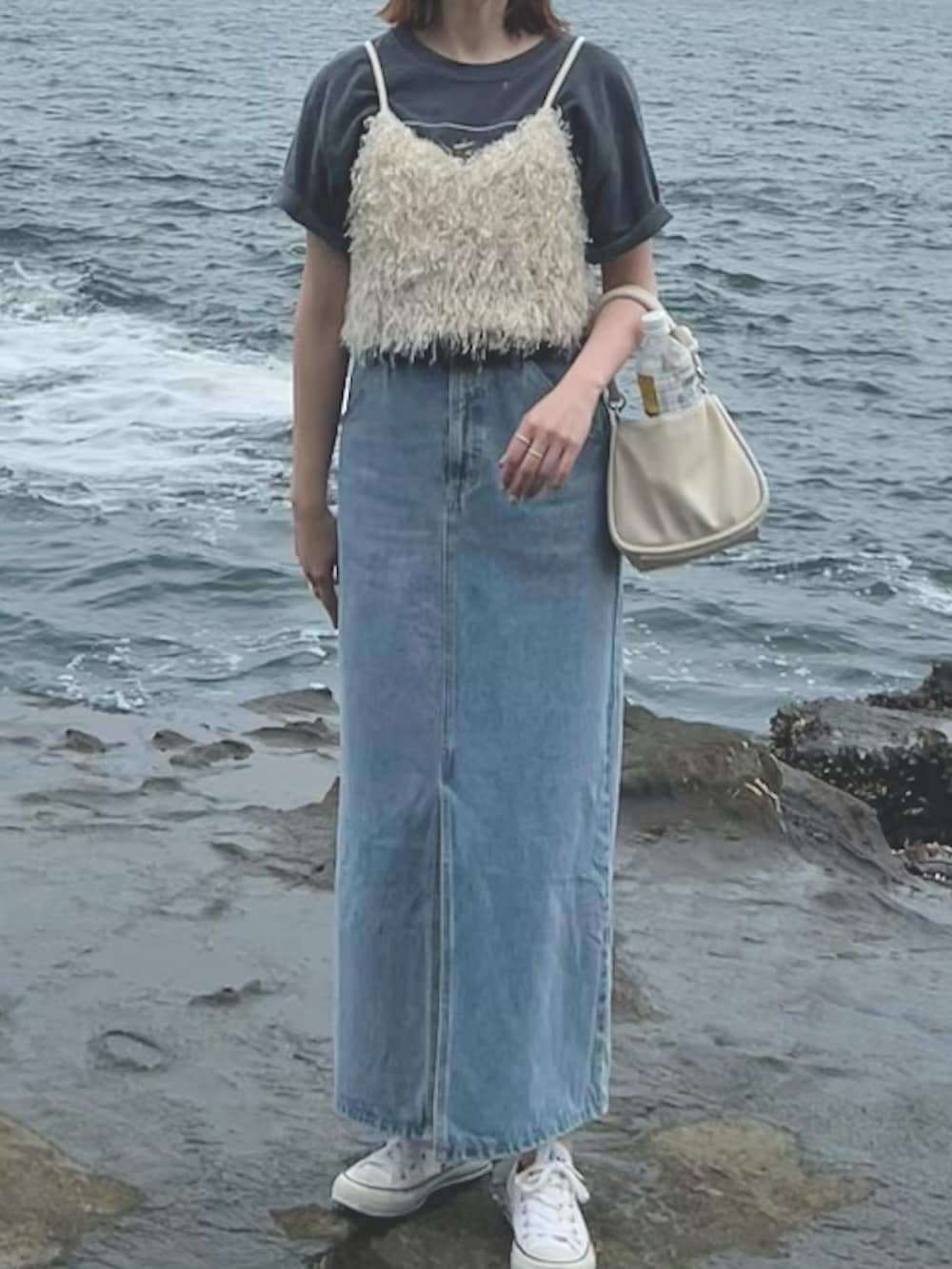 ホワイト系のシャツ/ブラウス、ホワイト系のハンドバッグ、ブルー系のデニムスカートを着用したレディースの春コーディネートの2枚目の写真