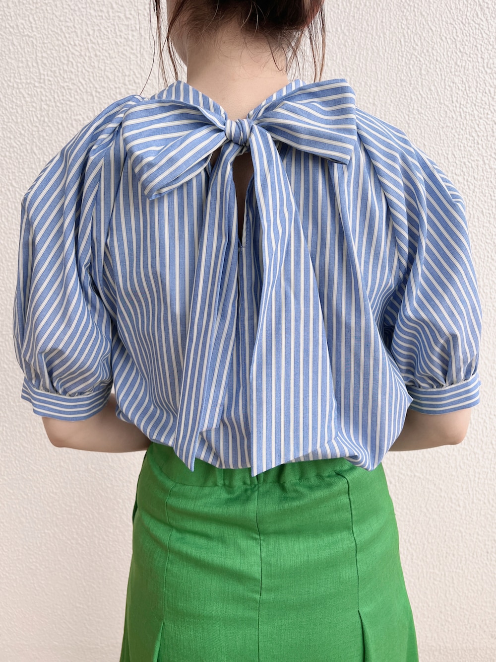 ブルー系のシャツ/ブラウス、グリーン系のスカート、イエロー系のハンドバッグを着用したレディースの春コーディネートの2枚目の写真