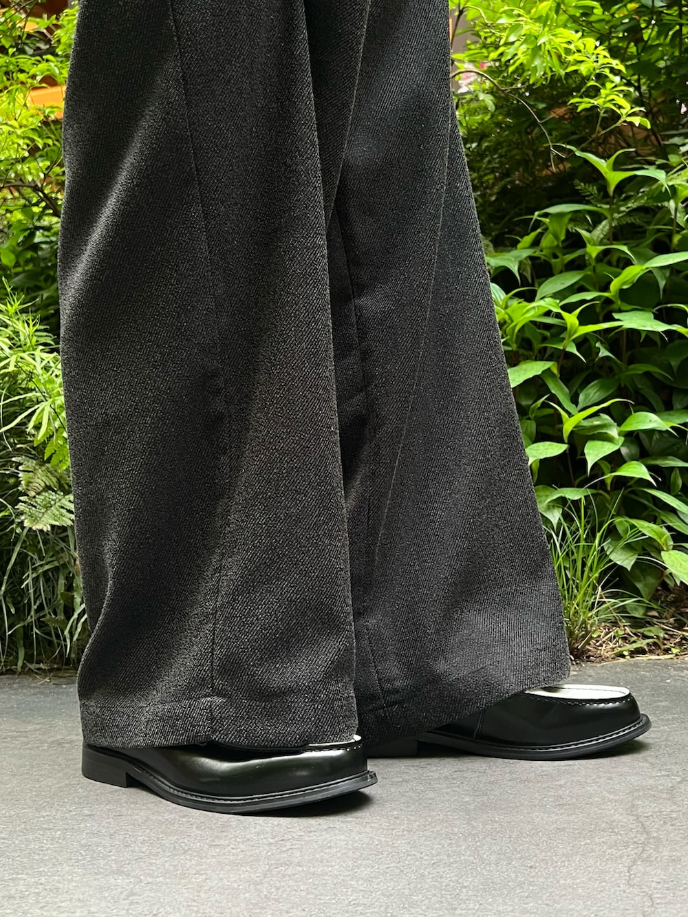 ブルー系のシャツ/ブラウス、ブラック系のニット/セーター、ブラック系のハンドバッグを着用したメンズの春コーディネートの2枚目の写真