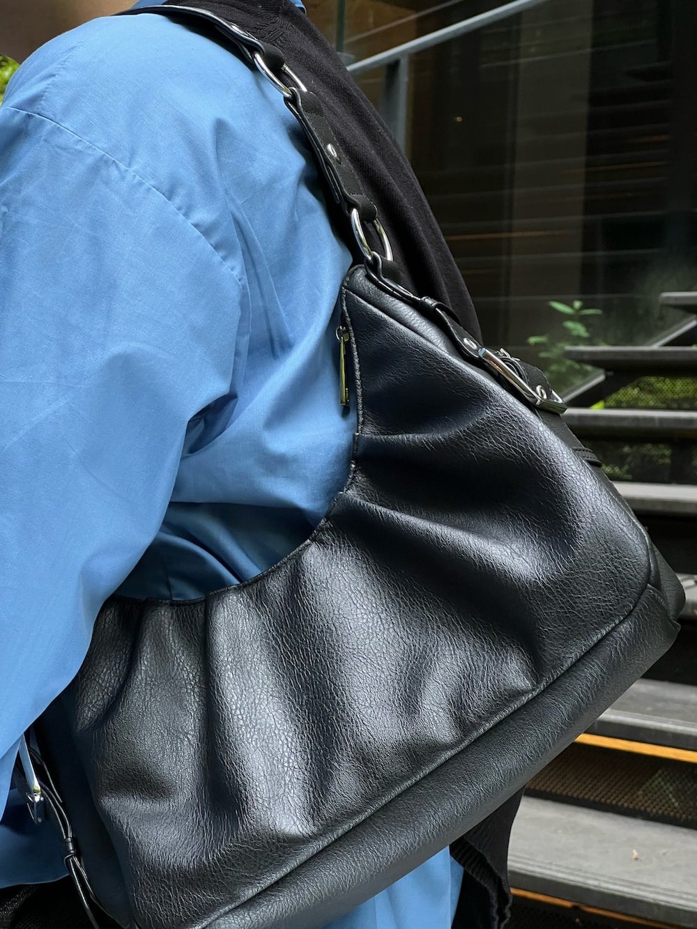 ブルー系のシャツ/ブラウス、ブラック系のニット/セーター、ブラック系のハンドバッグを着用したメンズの春コーディネートの3枚目の写真