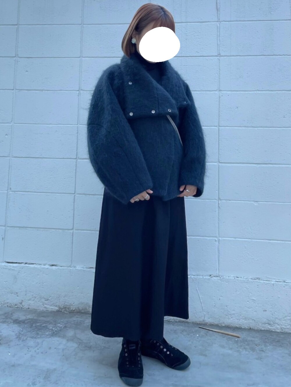 ブラック系のスニーカー、ブラック系のワンピース、ブラック系のその他アウターを着用したレディースの冬コーディネートの2枚目の写真