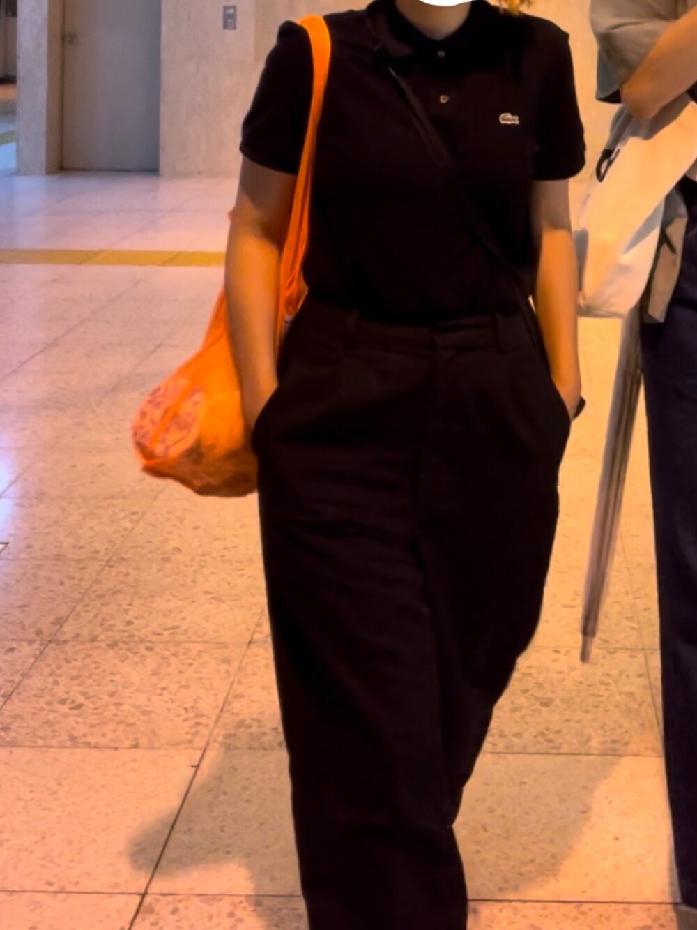 ブラック系のポロシャツ、ブラック系のその他パンツ、グリーン系のサンダルを着用したレディースの夏コーディネートの2枚目の写真