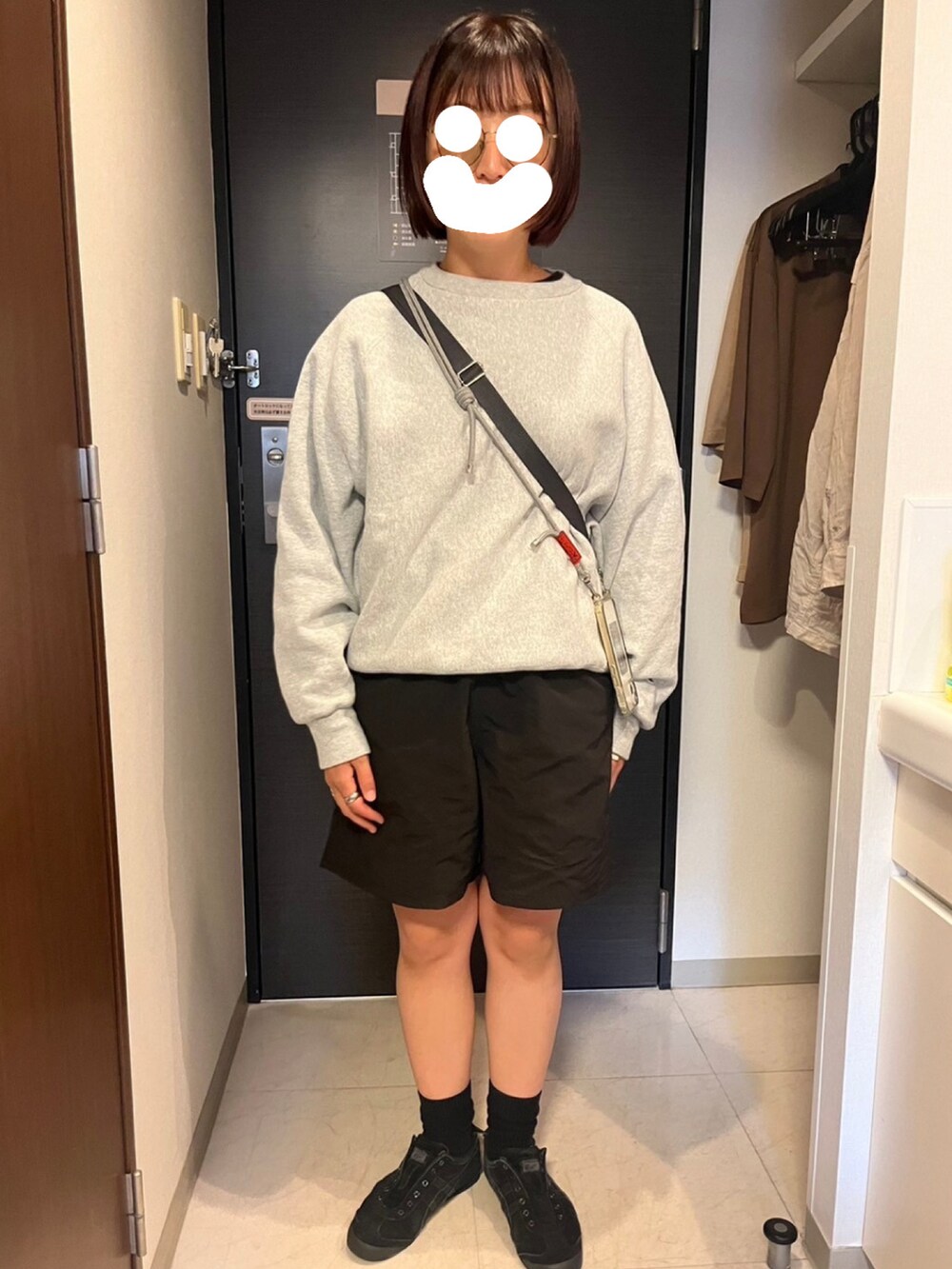 ブラック系のスニーカー、ブラック系のパンツ、グレー系のスウェットを着用したレディースの春コーディネートの2枚目の写真