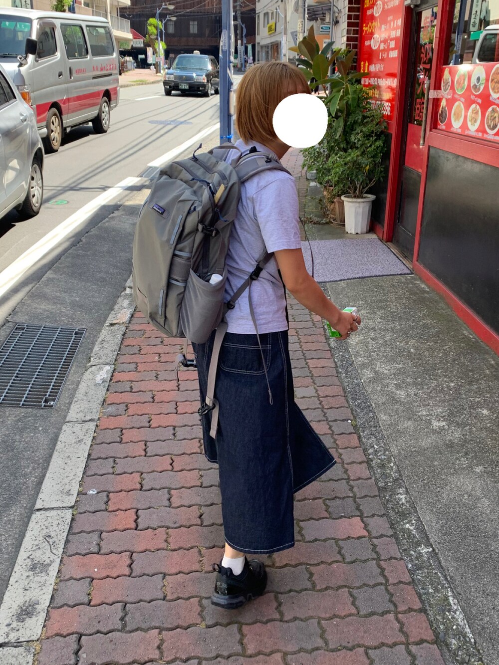 ブルー系のスカート、ブラック系のスニーカー、ブラック系のショルダーバッグを着用したレディースの夏コーディネートの2枚目の写真