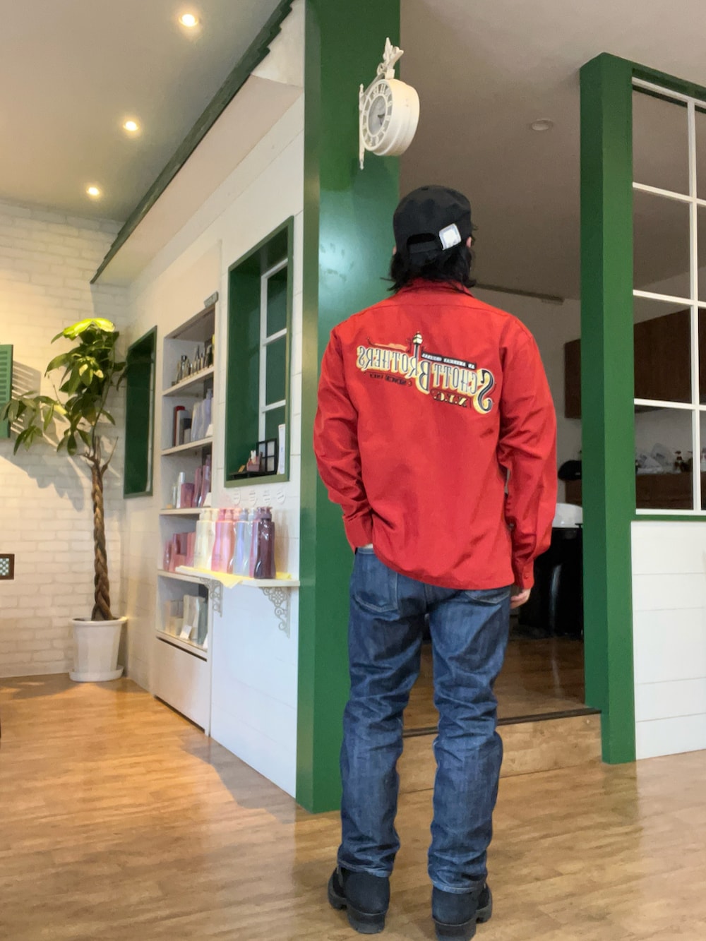 ブラック系のカーディガン/ボレロ、レッド系のシャツ/ブラウス、ブルー系のデニムパンツを着用したメンズの春コーディネートの2枚目の写真