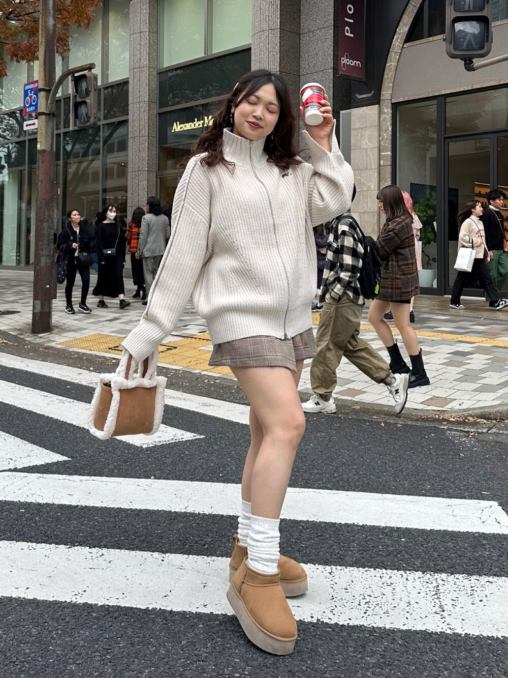 ブラウン系のブーツ、ブラウン系のハンドバッグ、ブラウン系のスカートを着用したレディースの秋コーディネートの3枚目の写真