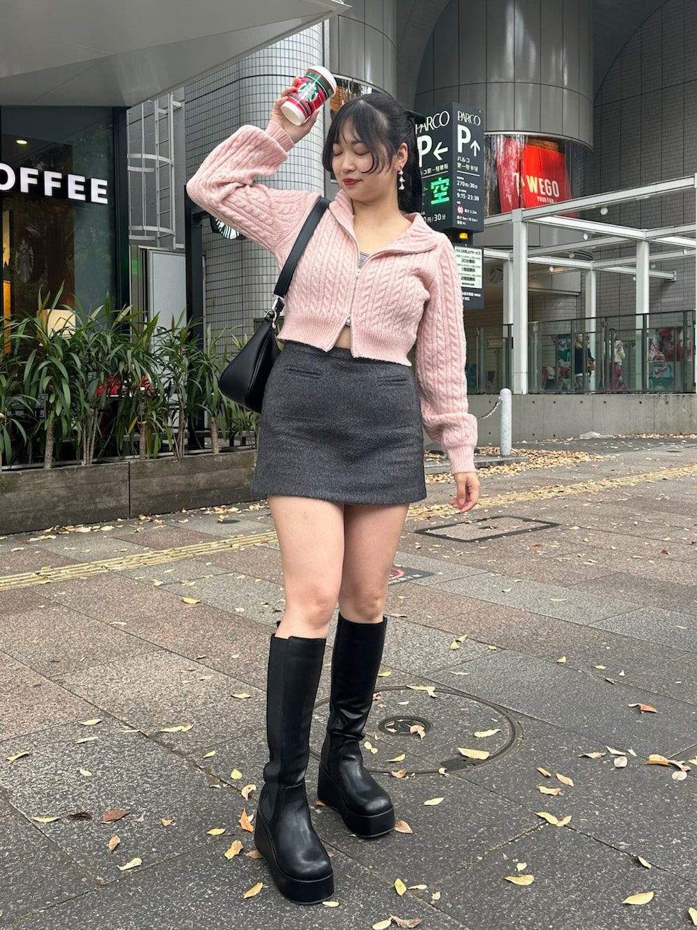 グレー系のスカート、ブラック系のブーツ、ピンク系のニット/セーターを着用したレディースの冬コーディネートの3枚目の写真