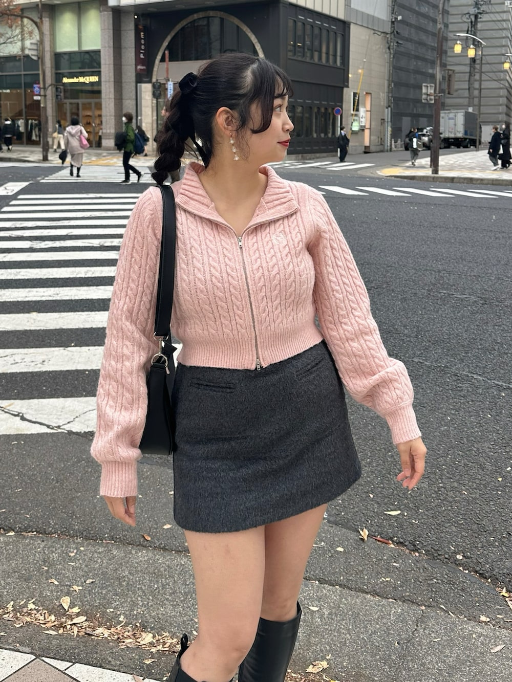 グレー系のスカート、ブラック系のブーツ、ピンク系のニット/セーターを着用したレディースの冬コーディネートの2枚目の写真