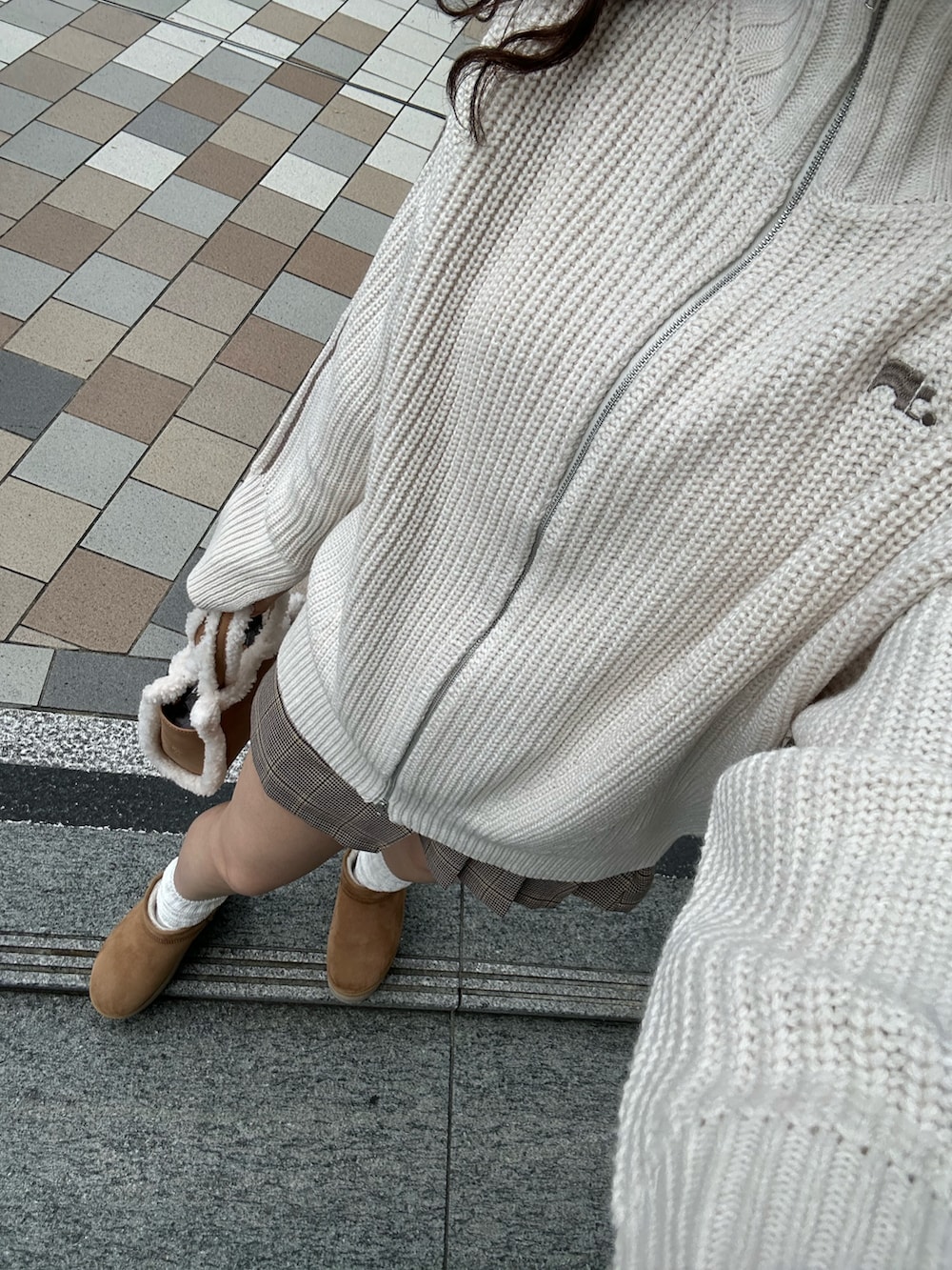 ブラウン系のブーツ、ブラウン系のハンドバッグ、ブラウン系のスカートを着用したレディースの秋コーディネートの4枚目の写真