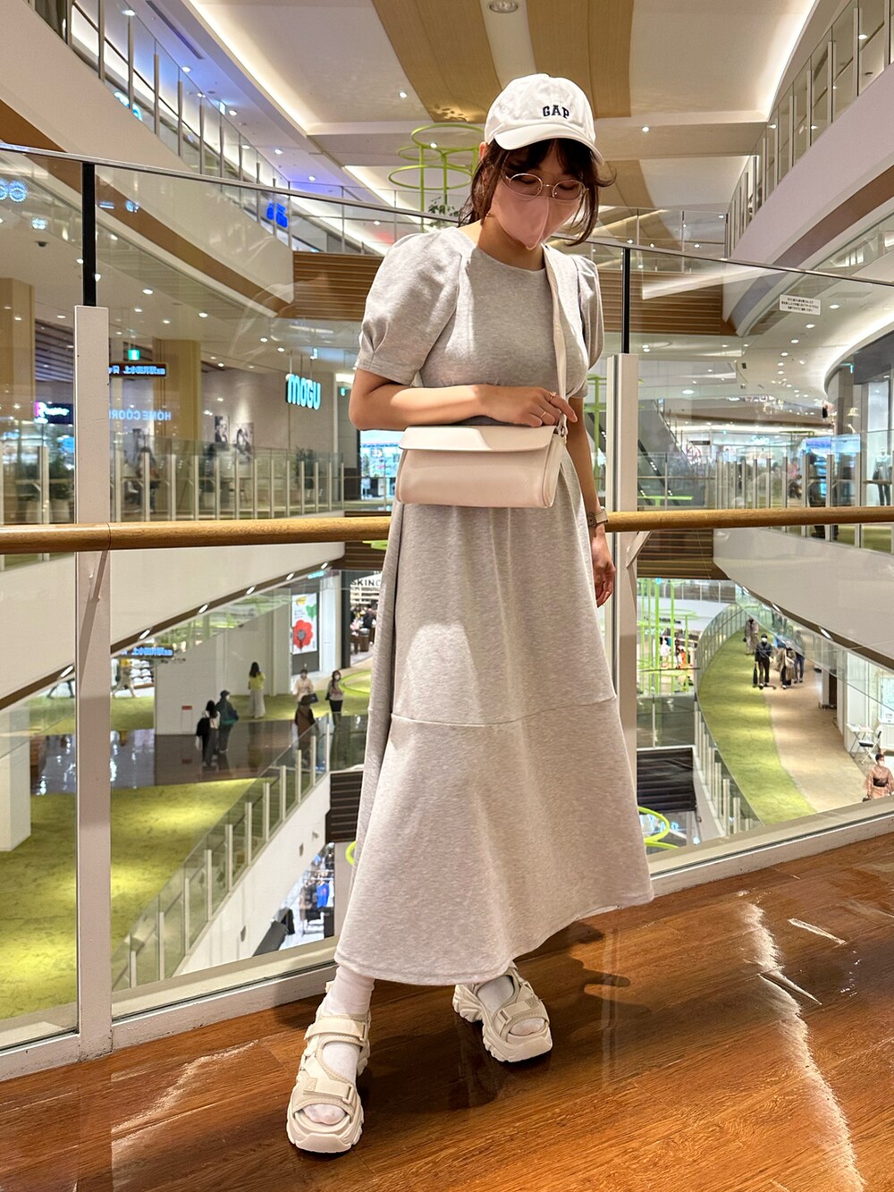 グレー系のワンピース/ドレス、ホワイト系のボディバッグ/ウエストポーチ、ホワイト系のキャップを着用したレディースの春コーディネートの2枚目の写真