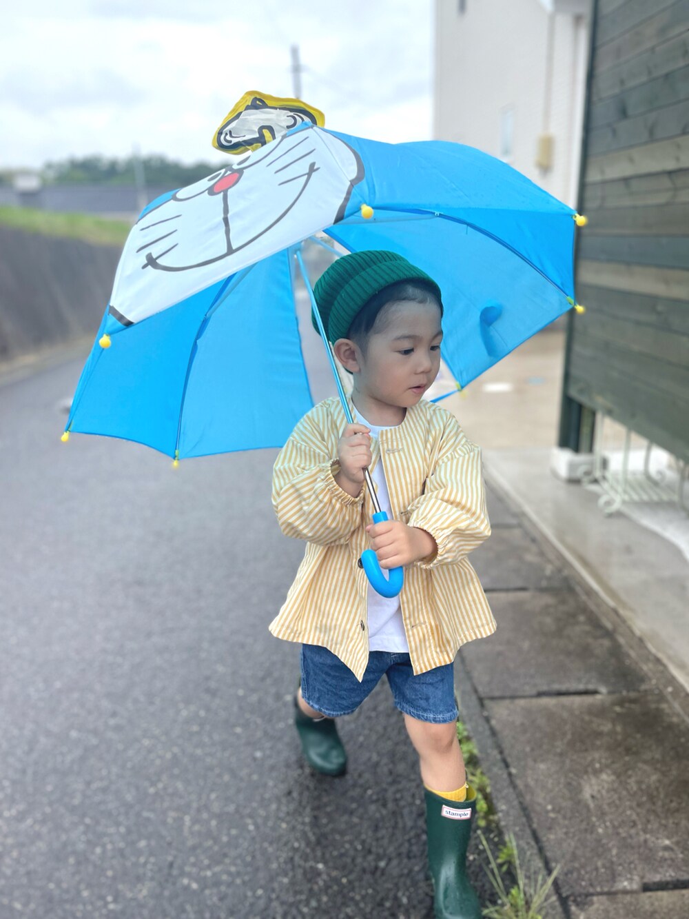 イエロー系のノーカラージャケット、ブルー系のその他パンツ、グリーン系のニットキャップ/ビーニーを着用したキッズの夏コーディネートの3枚目の写真