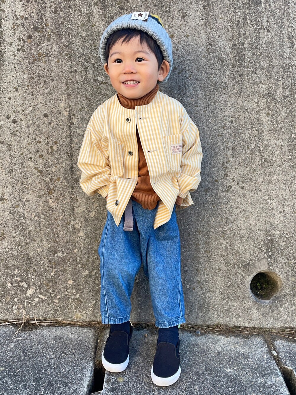 イエロー系のノーカラージャケット、イエロー系のニット/セーター、ブルー系のその他パンツを着用したキッズの秋コーディネートの4枚目の写真