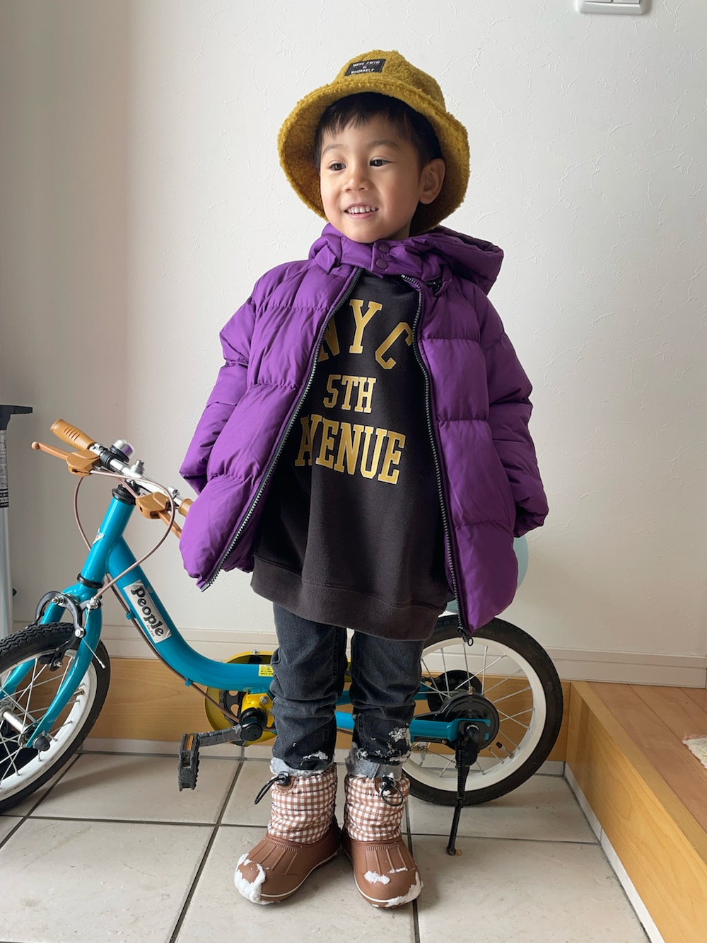 ブラック系のスウェット、パープル系のブルゾン、ブラック系のデニムパンツを着用したキッズの冬コーディネートの2枚目の写真