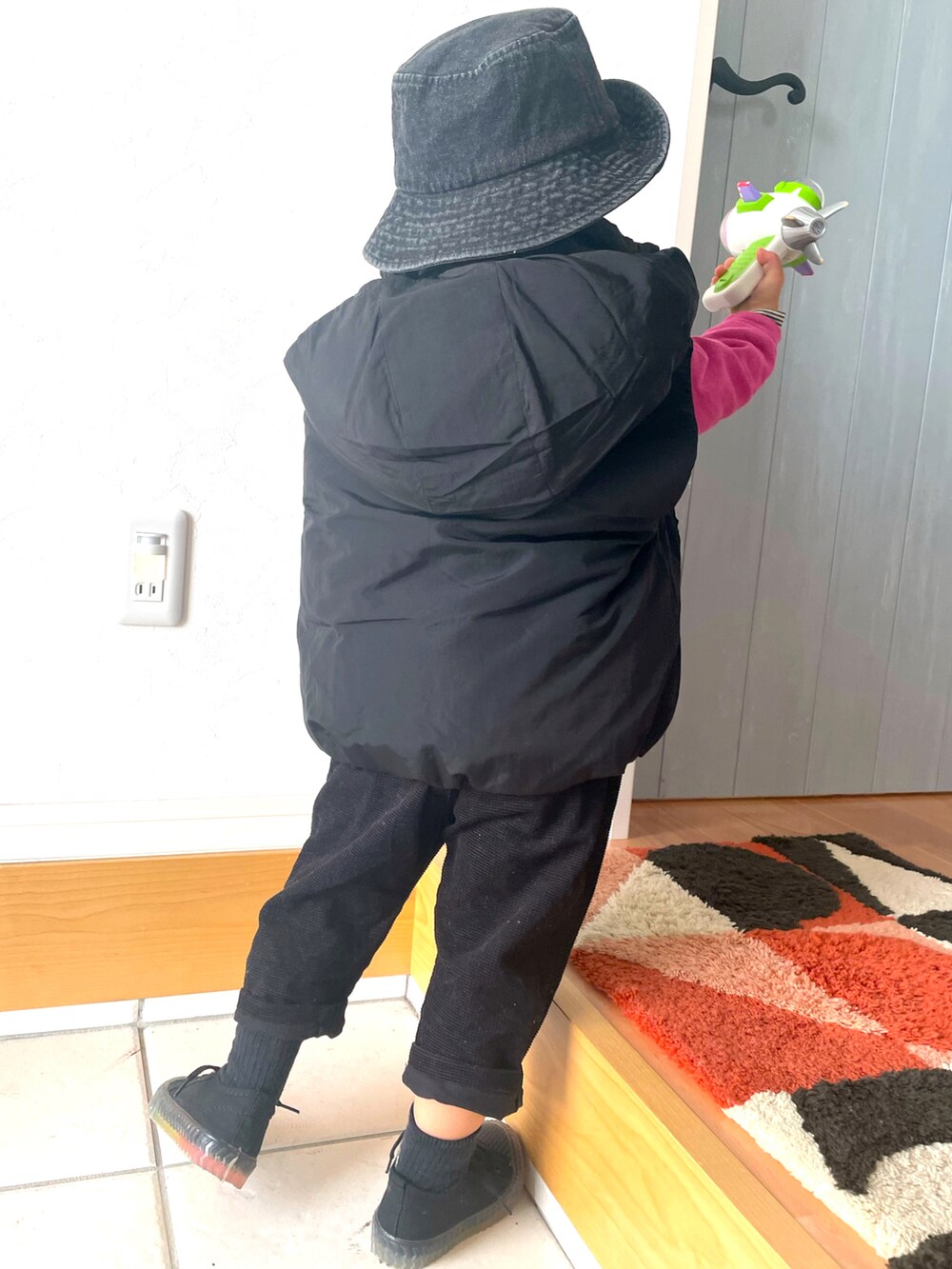 ピンク系のスウェット、ブラック系のダウンベスト、ブラック系のその他パンツを着用したキッズの冬コーディネートの5枚目の写真