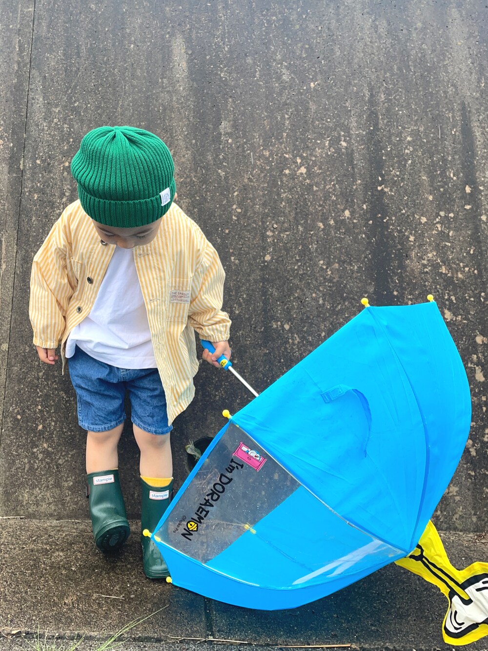 イエロー系のノーカラージャケット、ブルー系のその他パンツ、グリーン系のニットキャップ/ビーニーを着用したキッズの夏コーディネートの4枚目の写真