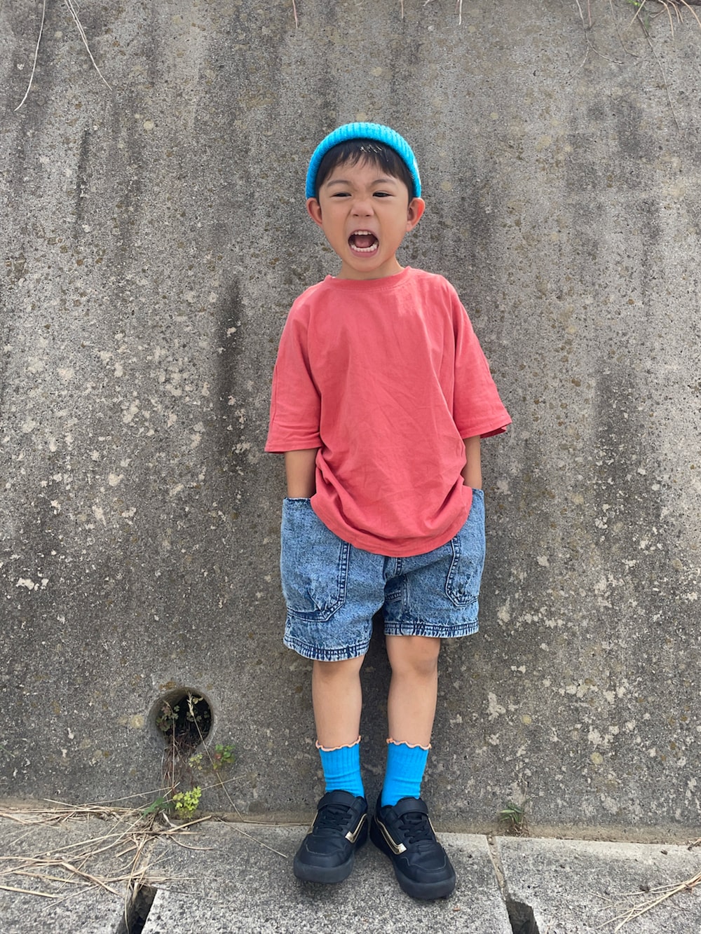 オレンジ系のTシャツ/カットソー、ブルー系のデニムパンツ、ブラック系のスニーカーを着用したキッズの夏コーディネートの2枚目の写真