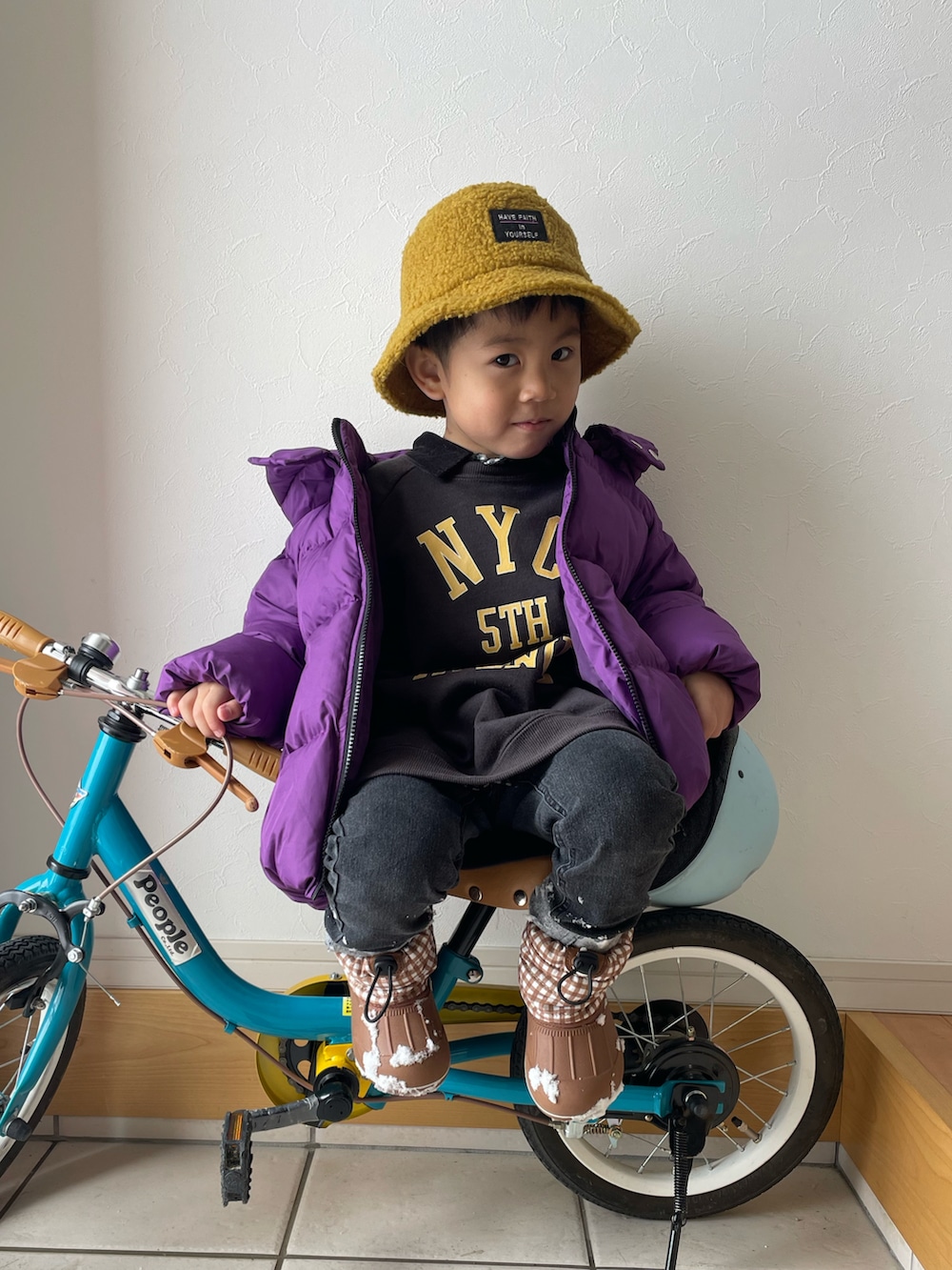 ブラック系のスウェット、パープル系のブルゾン、ブラック系のデニムパンツを着用したキッズの冬コーディネートの3枚目の写真