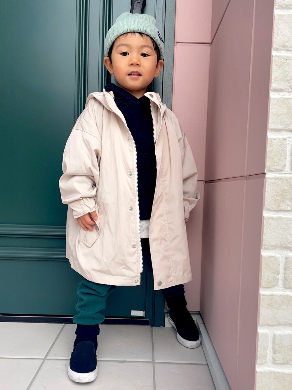 ブラック系のパーカー、ホワイト系のブルゾン、グリーン系のスウェットパンツを着用したキッズの秋コーディネートの5枚目の写真