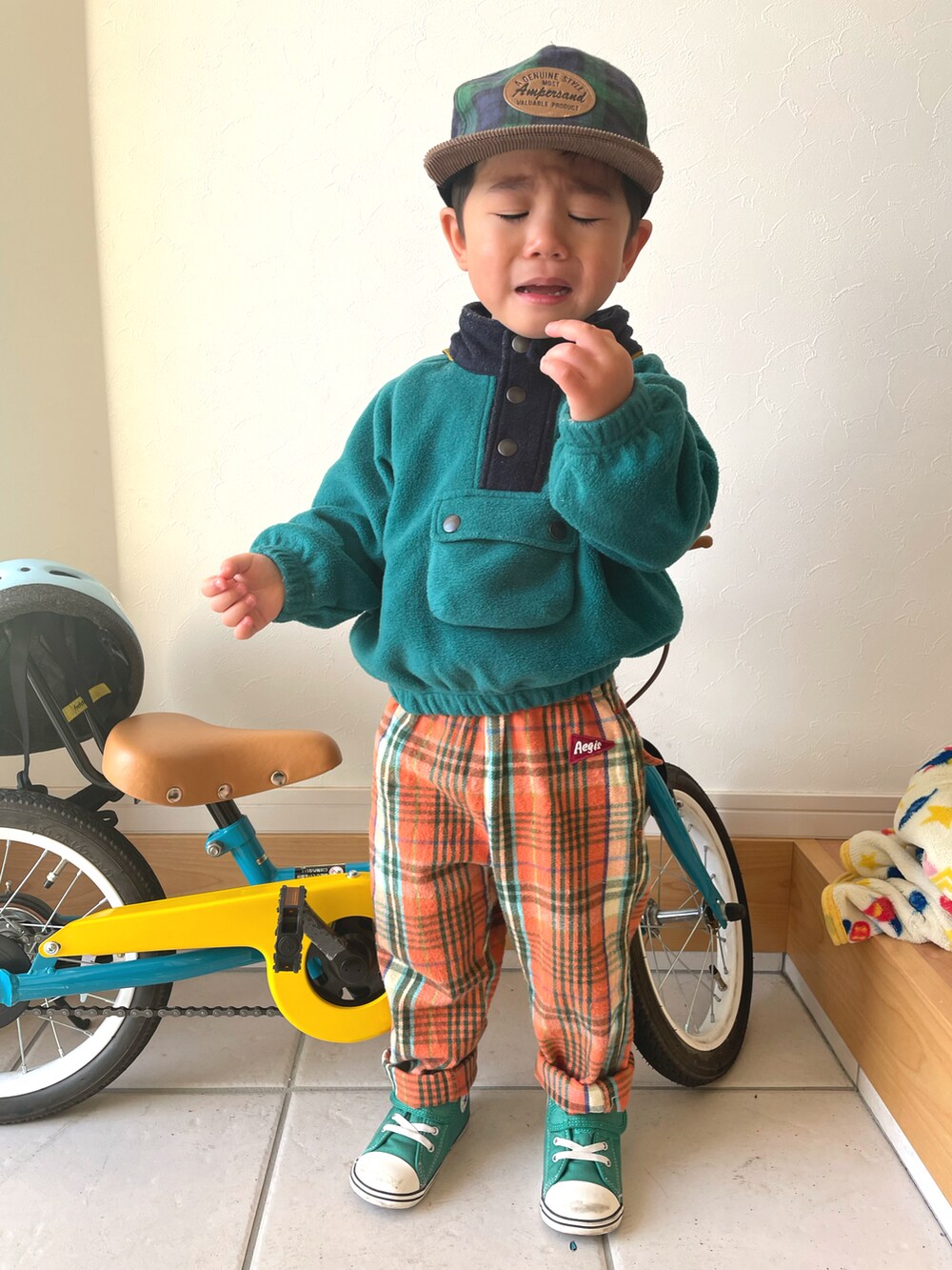 グリーン系のマウンテンパーカー、オレンジ系のその他パンツ、グリーン系のスニーカーを着用したキッズの冬コーディネートの3枚目の写真