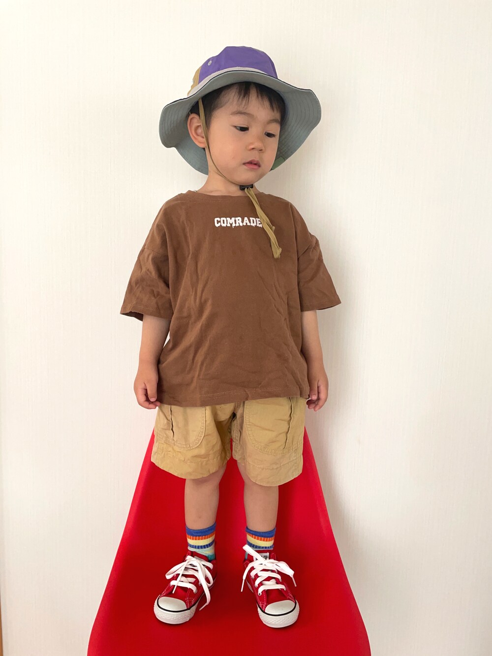 ブラウン系のTシャツ/カットソー、レッド系のスニーカー、ベージュ系のその他パンツを着用したキッズの春コーディネートの2枚目の写真