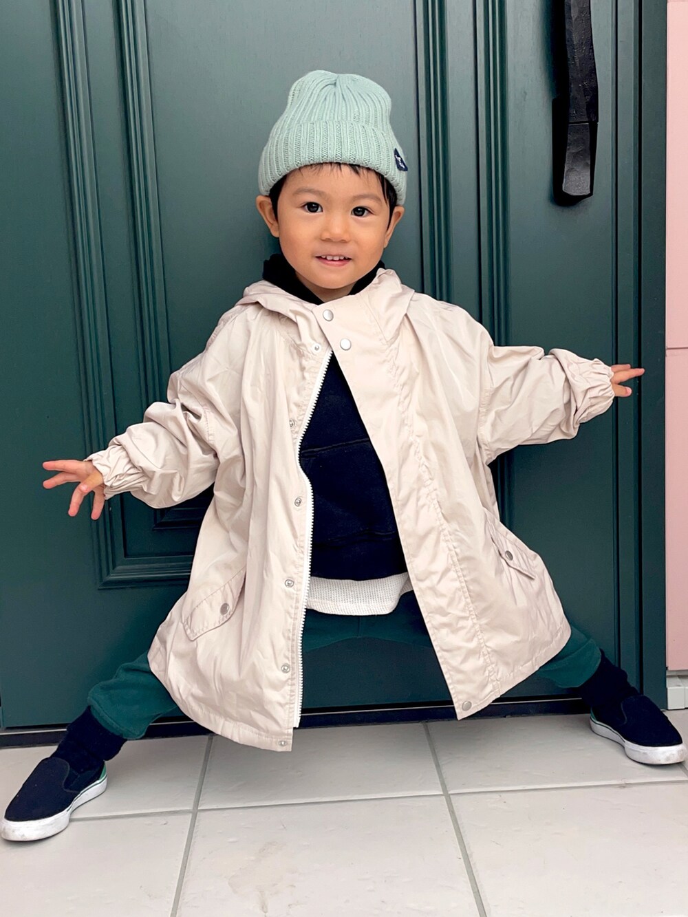 ブラック系のパーカー、ホワイト系のブルゾン、グリーン系のスウェットパンツを着用したキッズの秋コーディネートの3枚目の写真