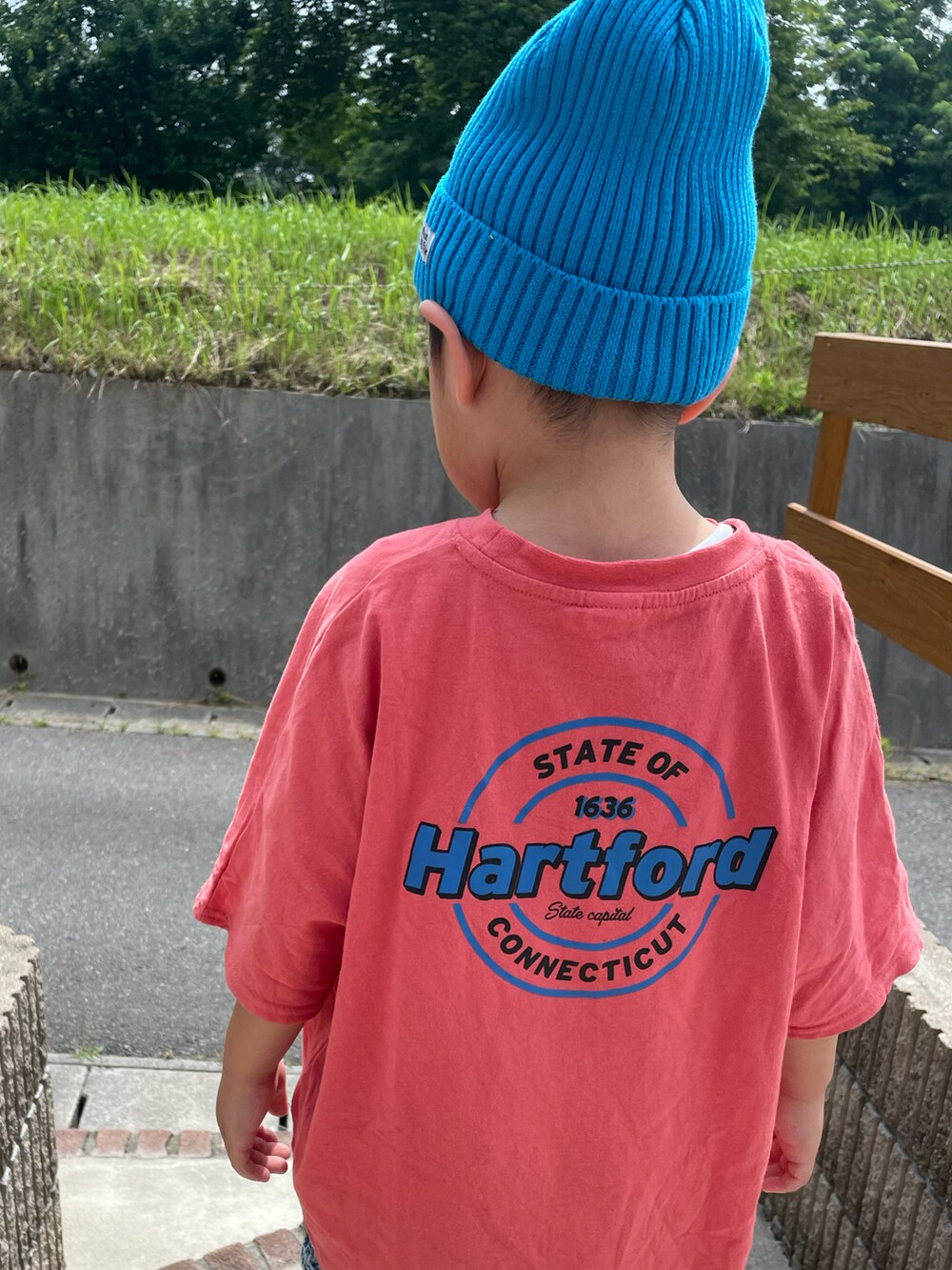 オレンジ系のTシャツ/カットソー、ブルー系のデニムパンツ、ブラック系のスニーカーを着用したキッズの夏コーディネートの4枚目の写真