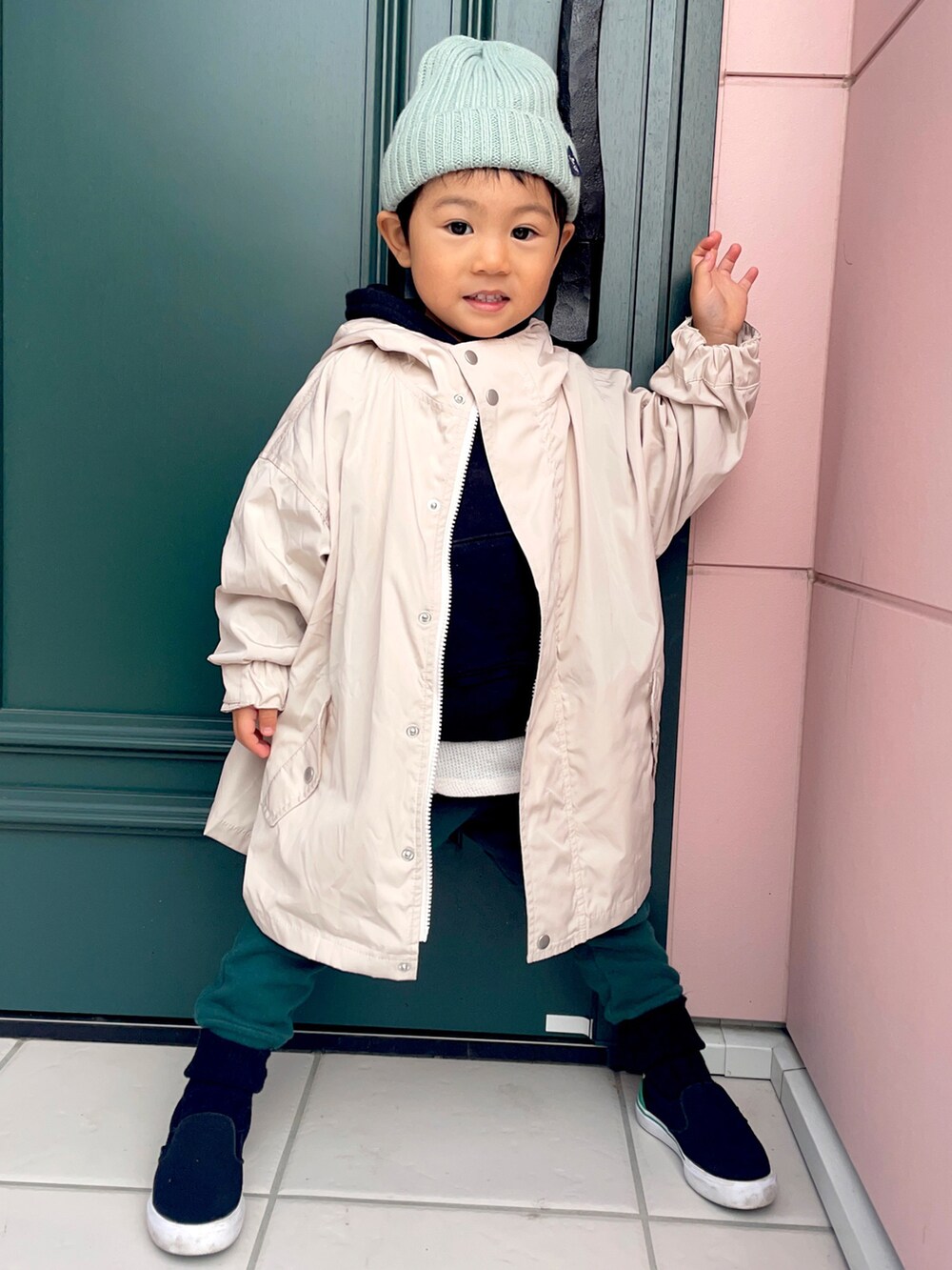 ブラック系のパーカー、ホワイト系のブルゾン、グリーン系のスウェットパンツを着用したキッズの秋コーディネートの2枚目の写真