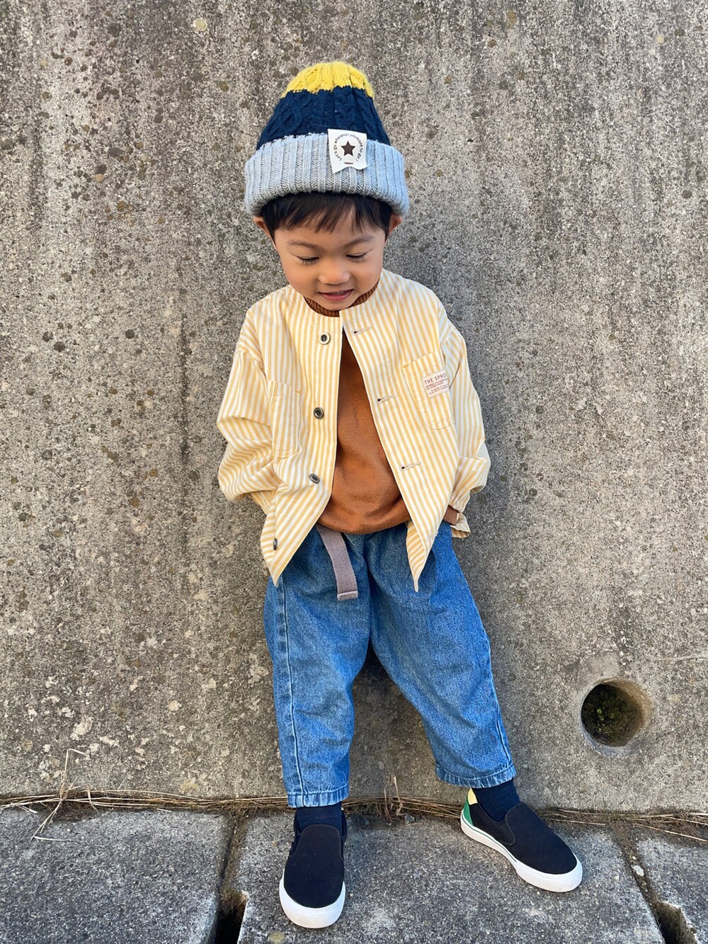 イエロー系のノーカラージャケット、イエロー系のニット/セーター、ブルー系のその他パンツを着用したキッズの秋コーディネートの3枚目の写真