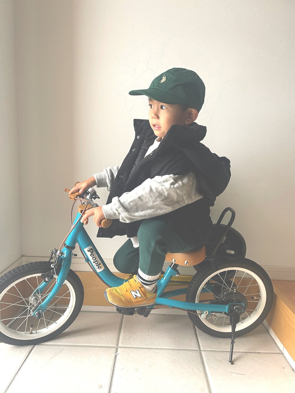 グレー系のスウェット、ブラック系のダウンベスト、グリーン系のスウェットパンツを着用したキッズの秋コーディネートの3枚目の写真