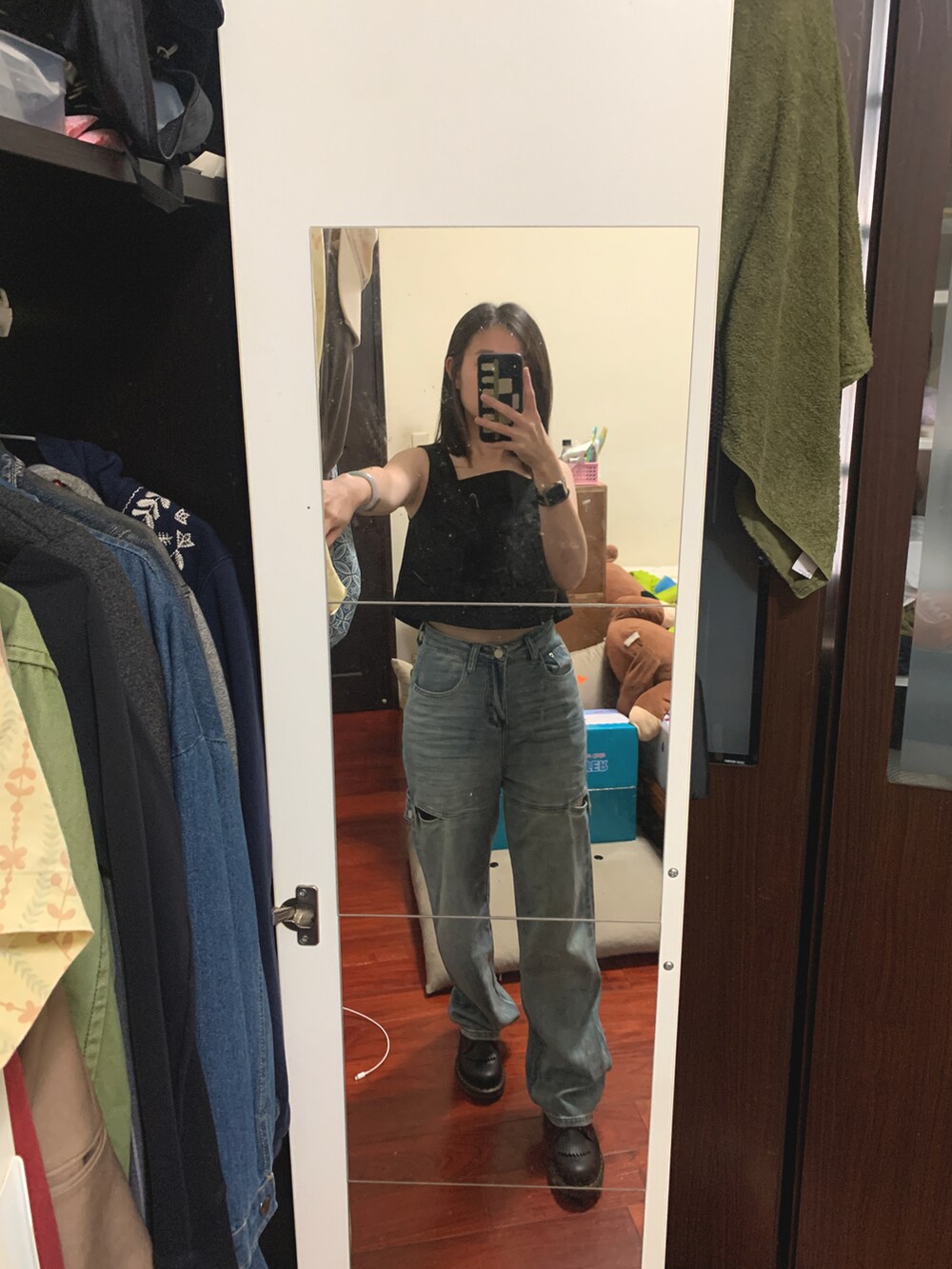 ブラック系のブーツ、ブルー系のデニムパンツ、ブラック系のその他トップスを着用したレディースの夏コーディネートの2枚目の写真