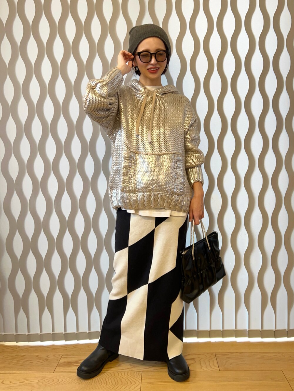 シルバー系のニット/セーター、ブラック系のハンドバッグ、ブラック系のスカートを着用したレディースの冬コーディネートの2枚目の写真