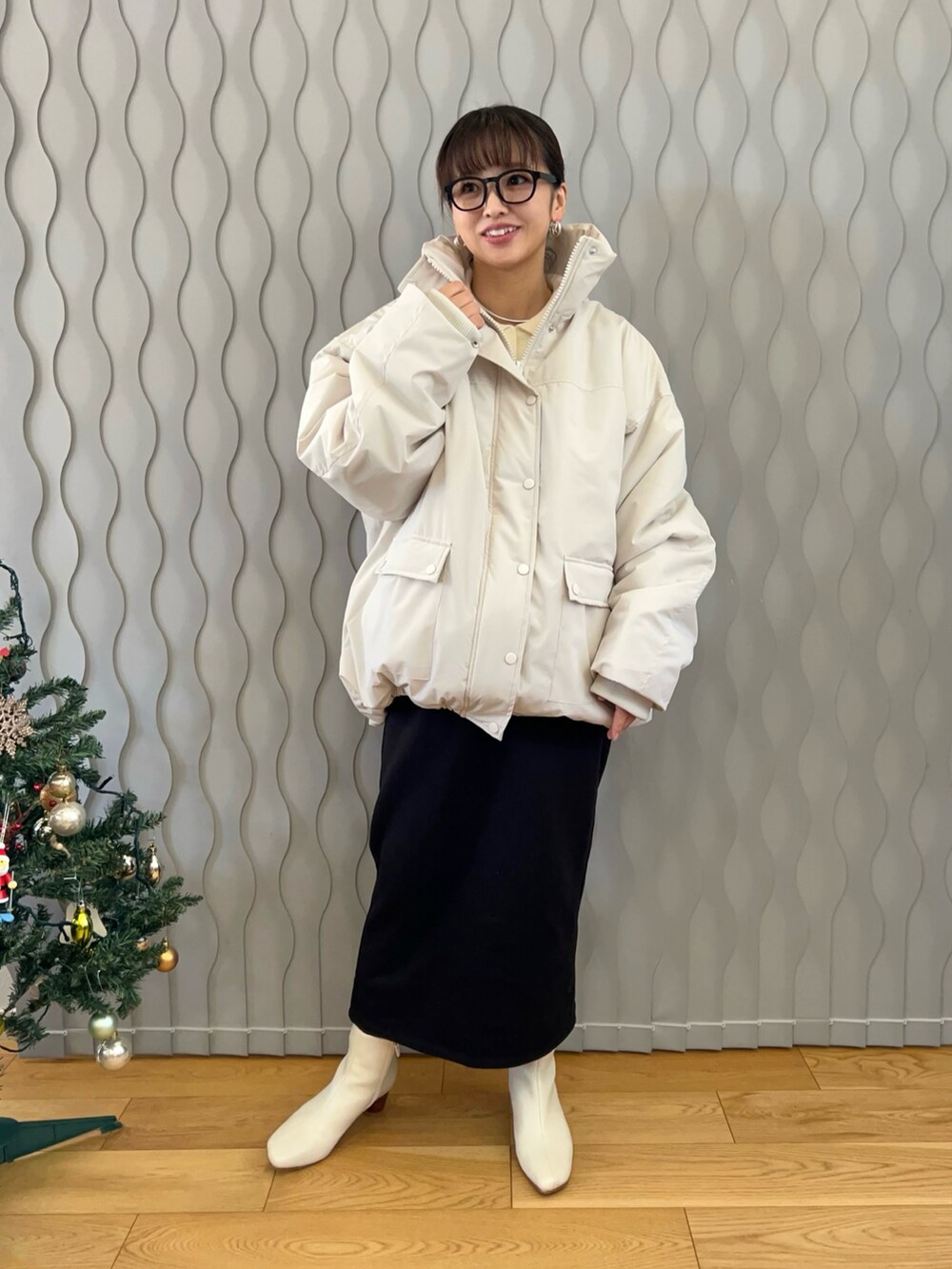 ホワイト系のブルゾン、ホワイト系のブーツ、ブラック系のスカートを着用したレディースの冬コーディネートの2枚目の写真