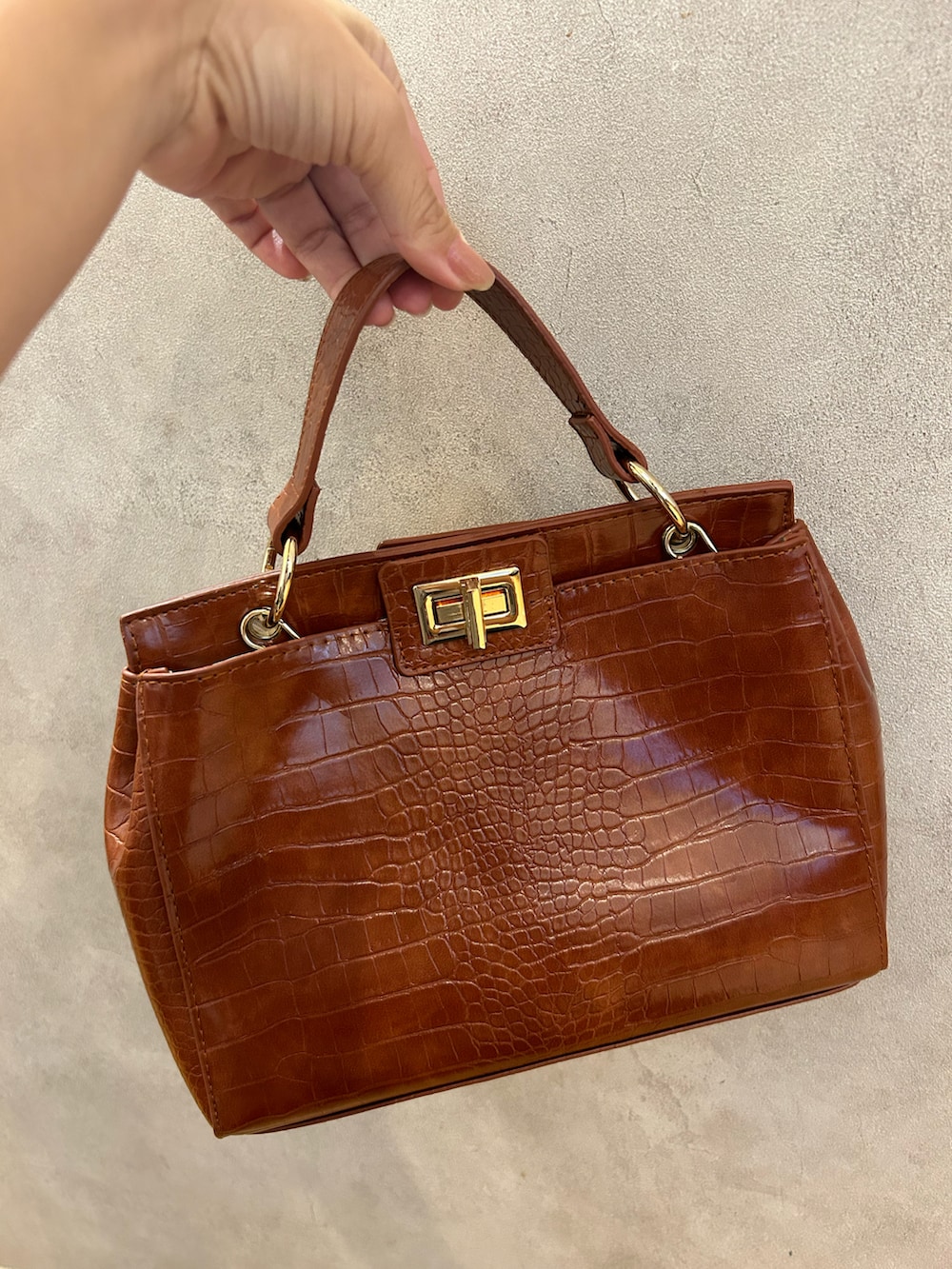 ホワイト系のその他アウター、ブラウン系のハンドバッグ、ホワイト系のブーツを着用したレディースの秋コーディネートの2枚目の写真