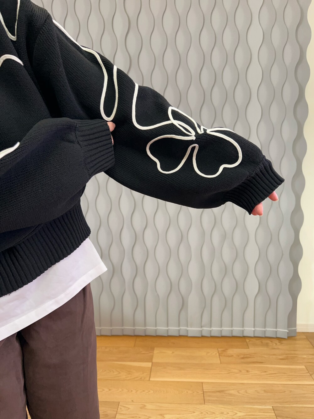 ブラック系のニット/セーター、ブラウン系のデニムパンツ、ベージュ系のスリッポンを着用したレディースの冬コーディネートの3枚目の写真