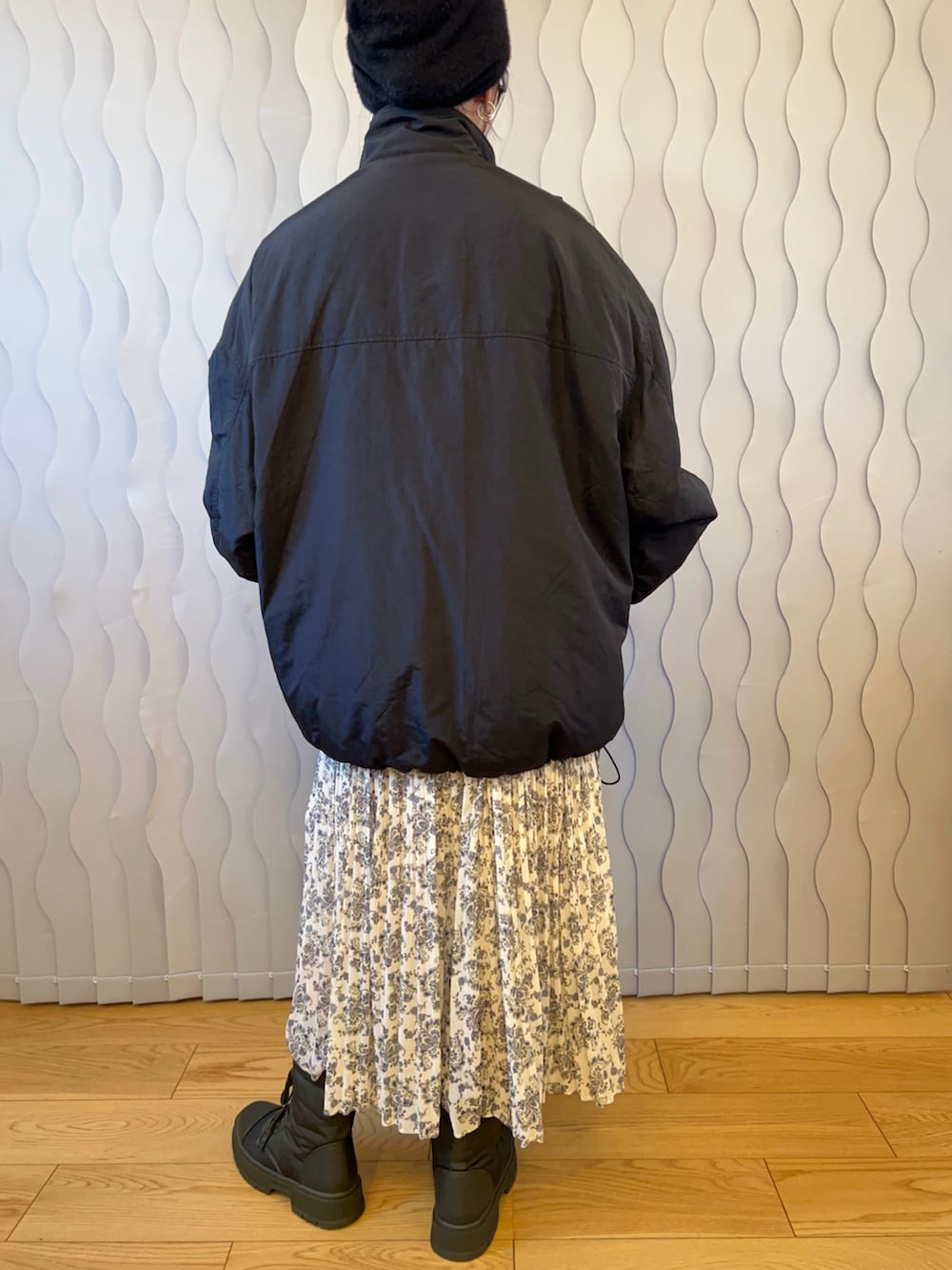 ブラック系のブルゾン、ホワイト系のワンピース、グリーン系のスニーカーを着用したレディースの秋コーディネートの4枚目の写真