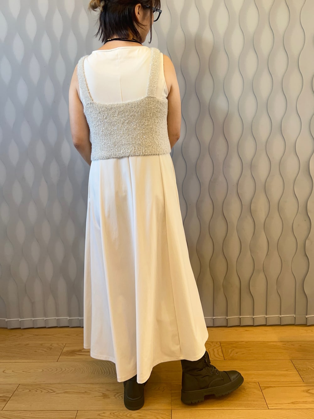 ホワイト系のベスト、ホワイト系のワンピース/ドレス、ブラック系のハンドバッグを着用したレディースの秋コーディネートの2枚目の写真